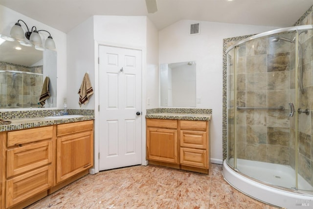 bathroom featuring lofted ceiling, visible vents, and a shower stall