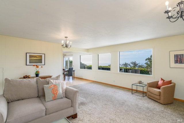 carpeted living room featuring baseboards and a notable chandelier