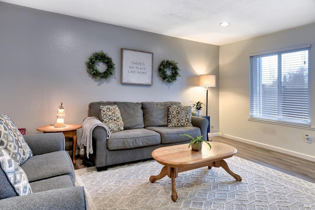 living room with baseboards, wood finished floors, and recessed lighting