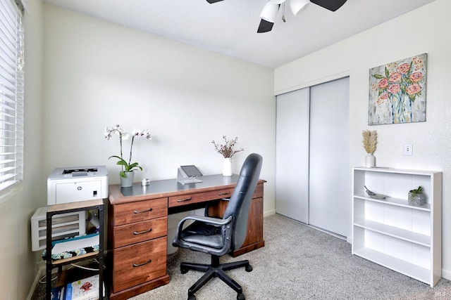 office space featuring light carpet and ceiling fan