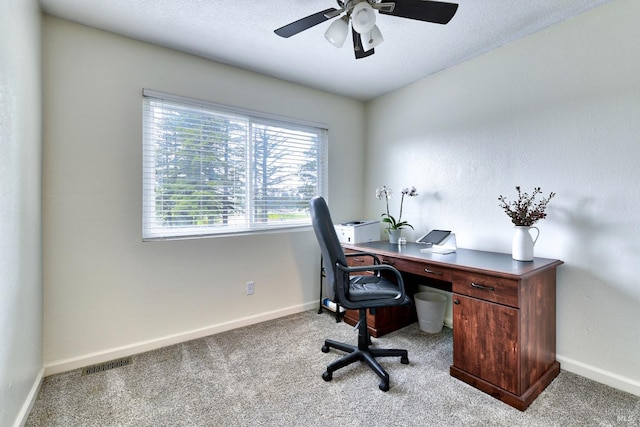 home office featuring visible vents, ceiling fan, light carpet, and baseboards
