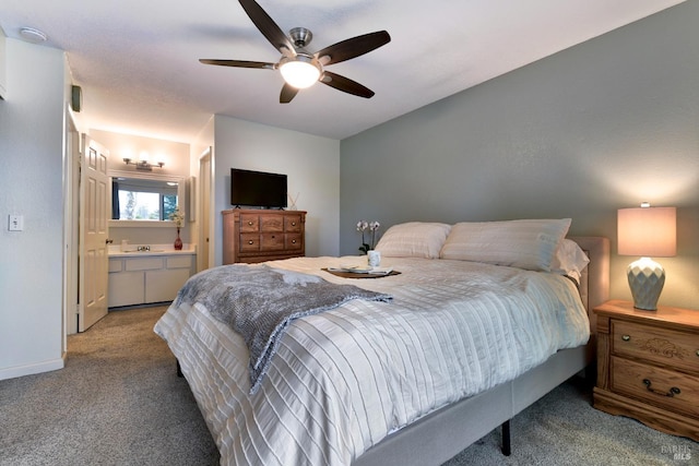 carpeted bedroom with a sink, ceiling fan, and ensuite bath
