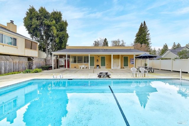 community pool with a patio and fence