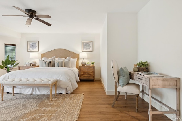 bedroom with ceiling fan, light wood-style flooring, and baseboards