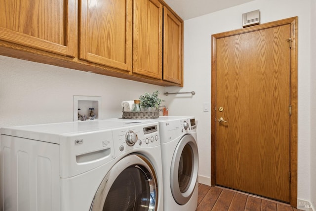 laundry area with wood finished floors, washing machine and clothes dryer, cabinet space, and baseboards