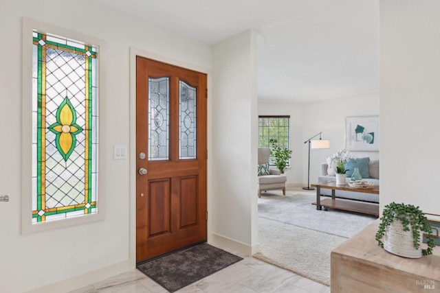 entrance foyer with marble finish floor and baseboards