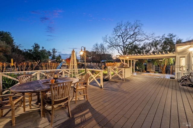 deck at dusk featuring outdoor dining area