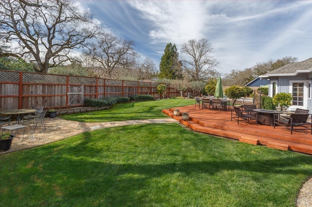 view of yard featuring a fire pit, outdoor dining area, a fenced backyard, and a wooden deck