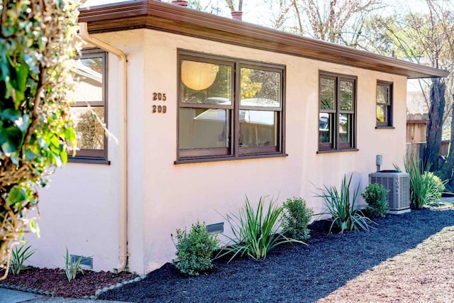 view of home's exterior featuring crawl space, cooling unit, and stucco siding