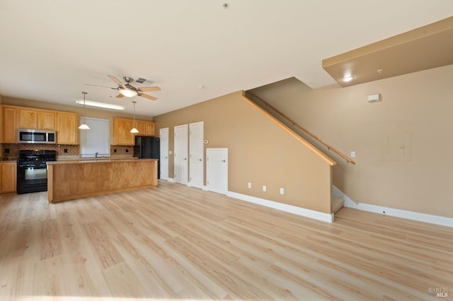 kitchen with light wood finished floors, ceiling fan, open floor plan, decorative backsplash, and black appliances