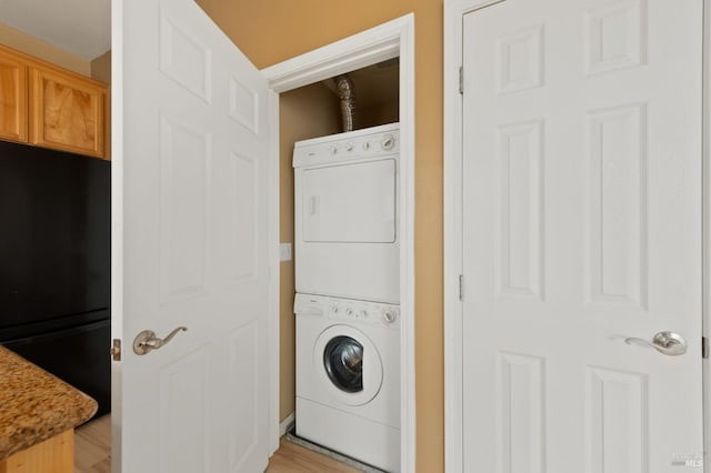 laundry room featuring stacked washer / drying machine and laundry area