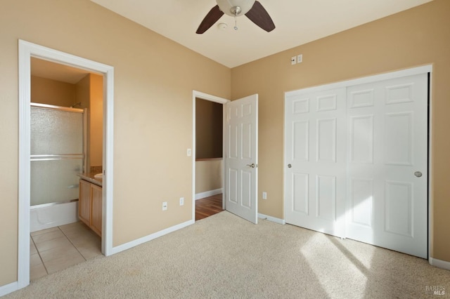 unfurnished bedroom with connected bathroom, light carpet, and baseboards