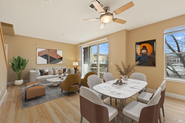 dining area with a wealth of natural light, baseboards, and light wood finished floors