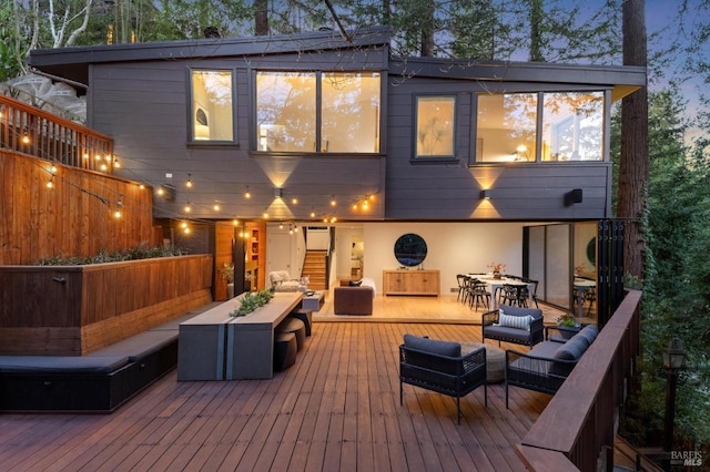 rear view of house featuring a deck, outdoor dining space, an outdoor living space, and stucco siding