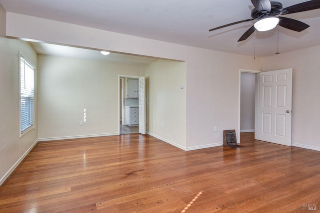 empty room featuring light wood-style flooring, baseboards, and ceiling fan