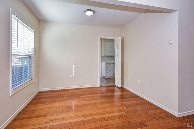 spare room featuring light wood finished floors and baseboards