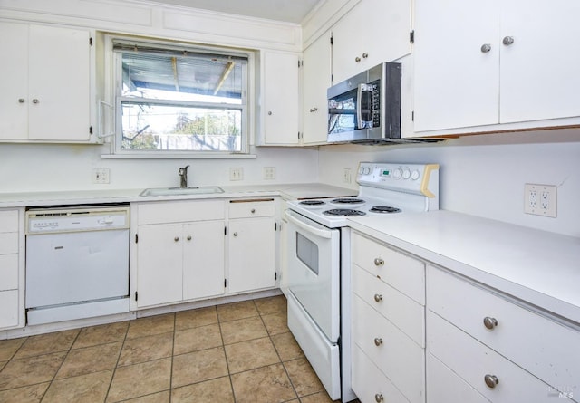 kitchen featuring white appliances, light countertops, a sink, and white cabinetry