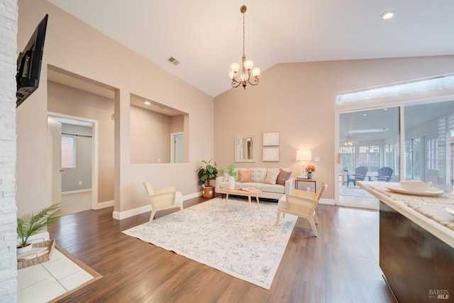 living room featuring dark wood finished floors, visible vents, vaulted ceiling, a chandelier, and baseboards