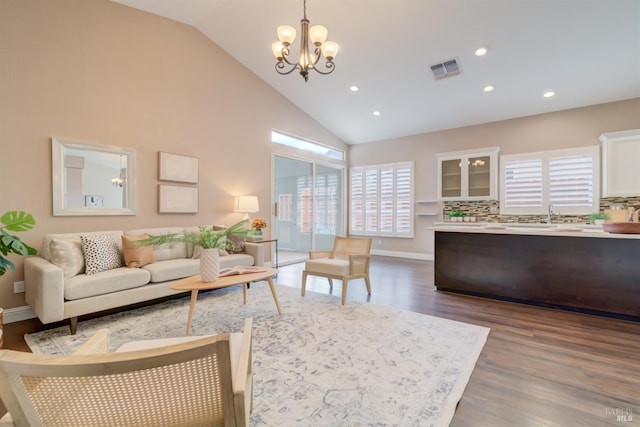 living room featuring high vaulted ceiling, recessed lighting, a notable chandelier, wood finished floors, and visible vents