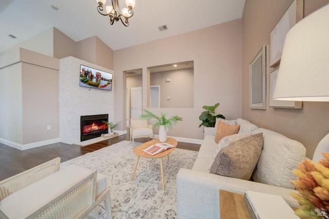 living room with dark wood-type flooring, a glass covered fireplace, visible vents, and baseboards