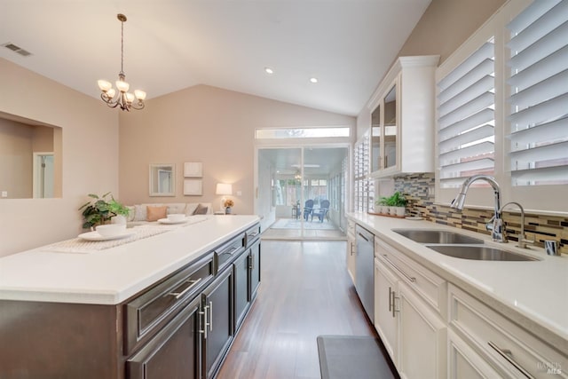 kitchen with white cabinets, light countertops, a sink, and stainless steel dishwasher