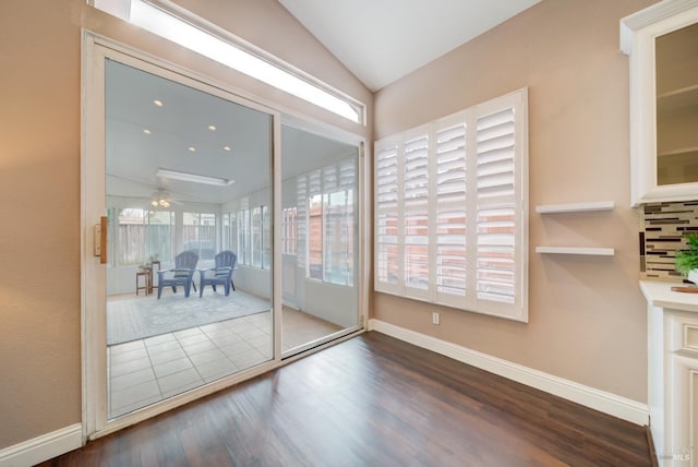 doorway to outside with lofted ceiling, dark wood-type flooring, a ceiling fan, and baseboards