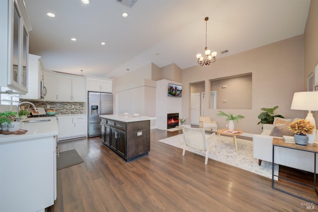 kitchen featuring appliances with stainless steel finishes, a center island, hanging light fixtures, light countertops, and white cabinetry