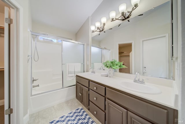 full bath featuring double vanity, combined bath / shower with glass door, a walk in closet, and a sink