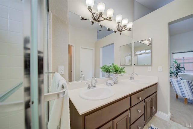 bathroom with a sink, an inviting chandelier, and double vanity