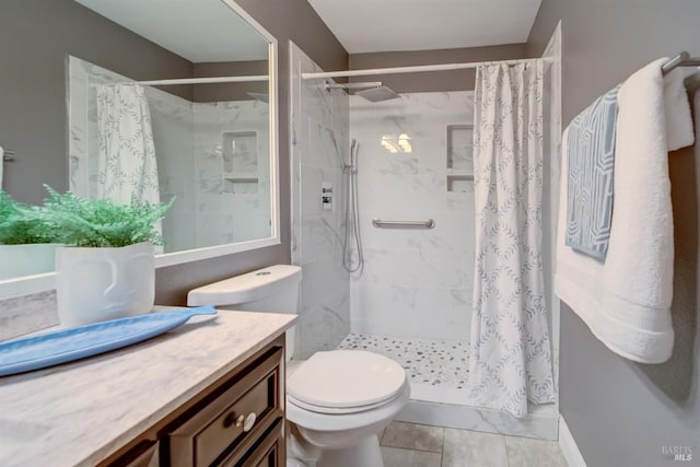 bathroom featuring toilet, a shower stall, and vanity