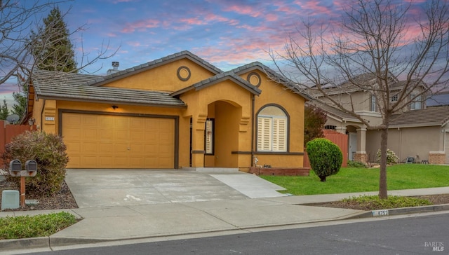 view of front of home with concrete driveway, stucco siding, a tiled roof, an attached garage, and a front yard