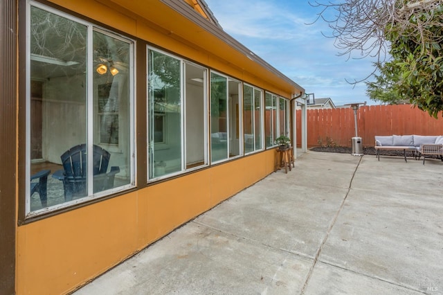 view of home's exterior with a patio area, fence, and an outdoor hangout area