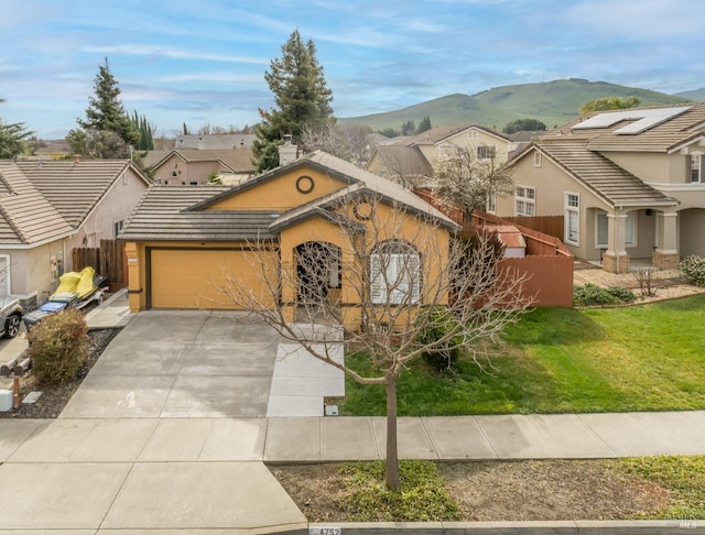 view of front of property with a mountain view, fence, a garage, a residential view, and driveway