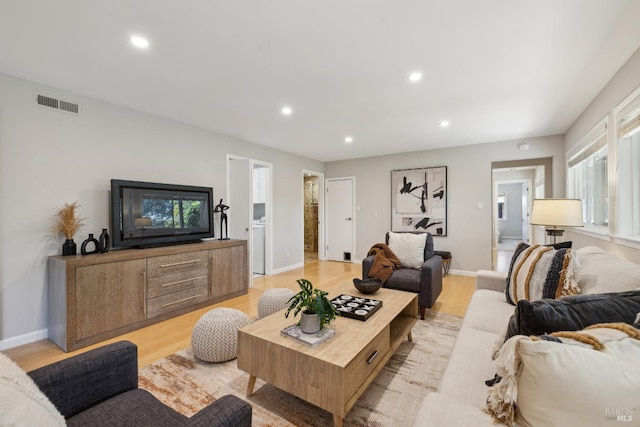 living room with light wood-style floors, baseboards, visible vents, and recessed lighting