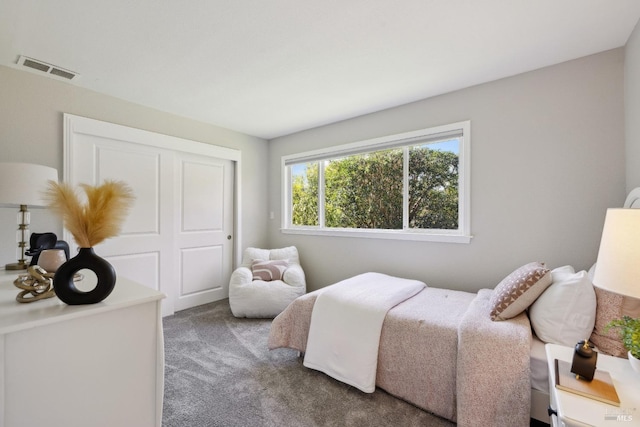 carpeted bedroom featuring a closet and visible vents