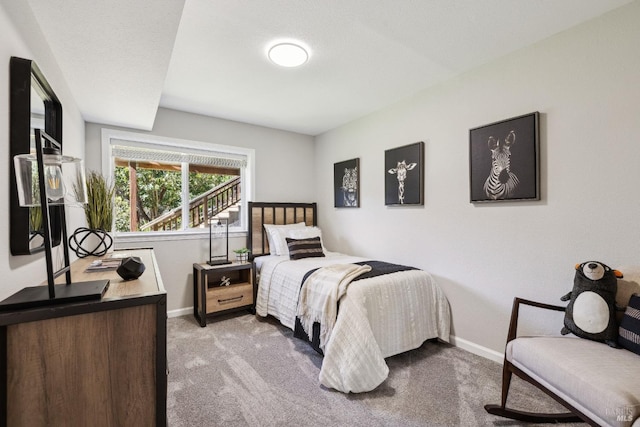 bedroom with baseboards and light colored carpet