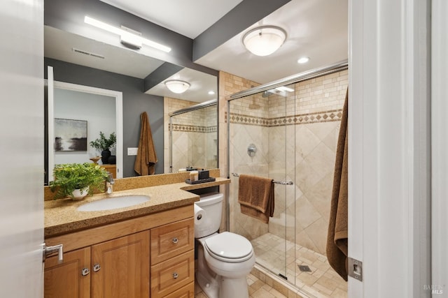 full bath with toilet, a stall shower, visible vents, and vanity