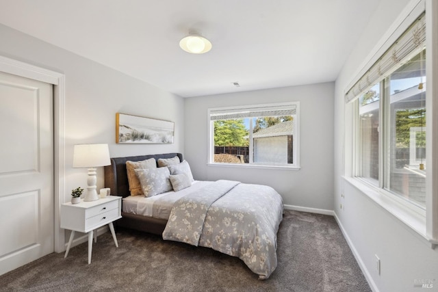 bedroom with dark colored carpet and baseboards