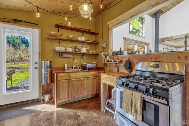 kitchen featuring concrete flooring, stainless steel range with gas stovetop, and a sink