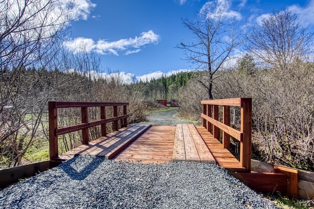 wooden terrace featuring a wooded view