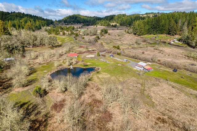 drone / aerial view with a wooded view