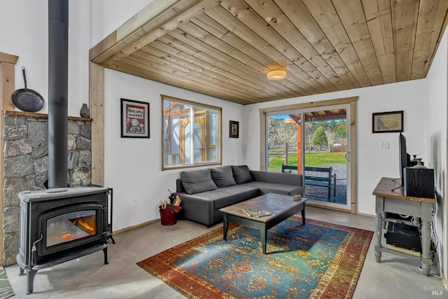 living room with a wood stove, wood ceiling, and baseboards