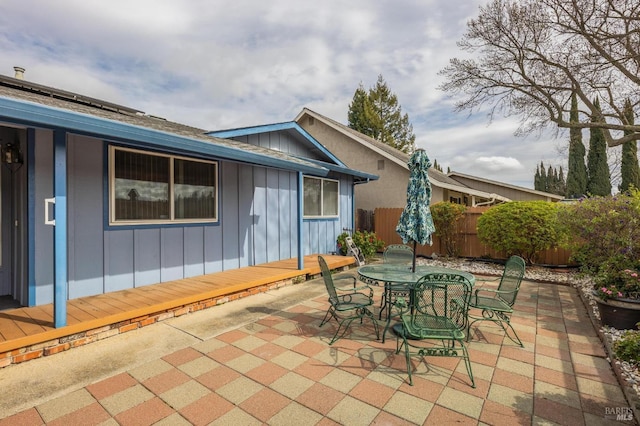 view of patio with outdoor dining space and fence