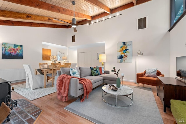 living room with wood ceiling, ceiling fan, beamed ceiling, light wood-type flooring, and high vaulted ceiling