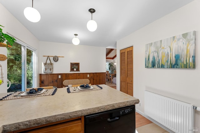 kitchen with black dishwasher, hanging light fixtures, light countertops, and radiator