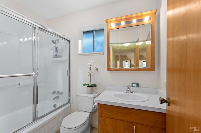 full bath with toilet, shower / bath combination with glass door, and vanity