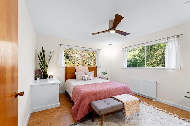 bedroom with radiator, ceiling fan, and baseboards