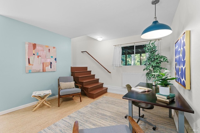 sitting room with radiator heating unit, stairs, baseboards, and wood finished floors