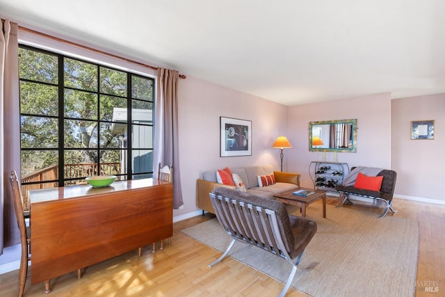 living area with light wood-type flooring and baseboards