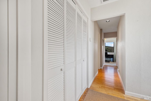 hallway with baseboards and wood finished floors